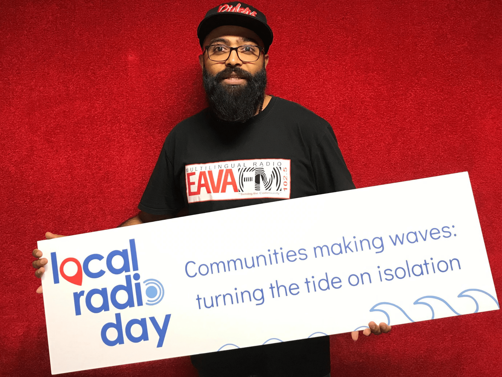 Vijay Umrao from multilingual radio station EAVA holds Local Radio Day sign