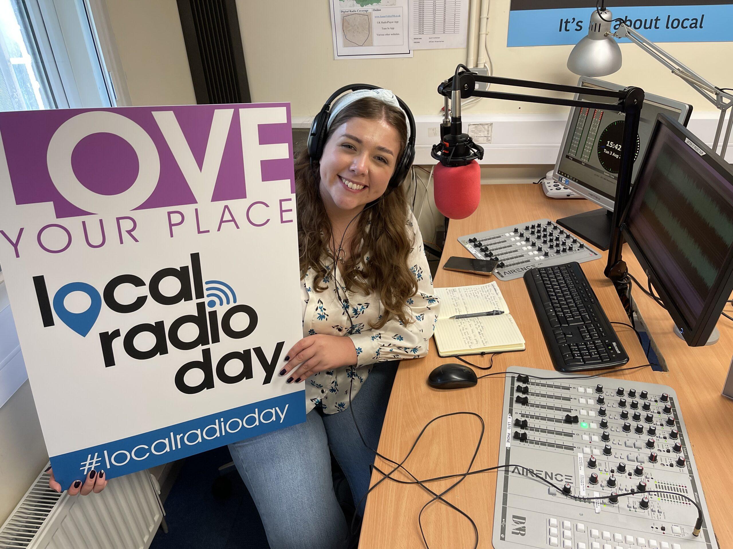 Gwen poses with Local Radio Day sign in community radio station Somer Valley FM's studio